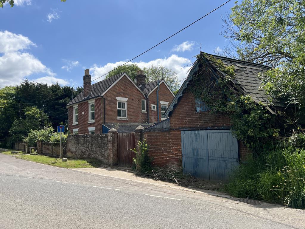 Lot: 129 - FOUR-BEDROOM HOUSE IN NEED OF IMPROVEMENT - View of garage and brick boundary wall of Rivermead cottage